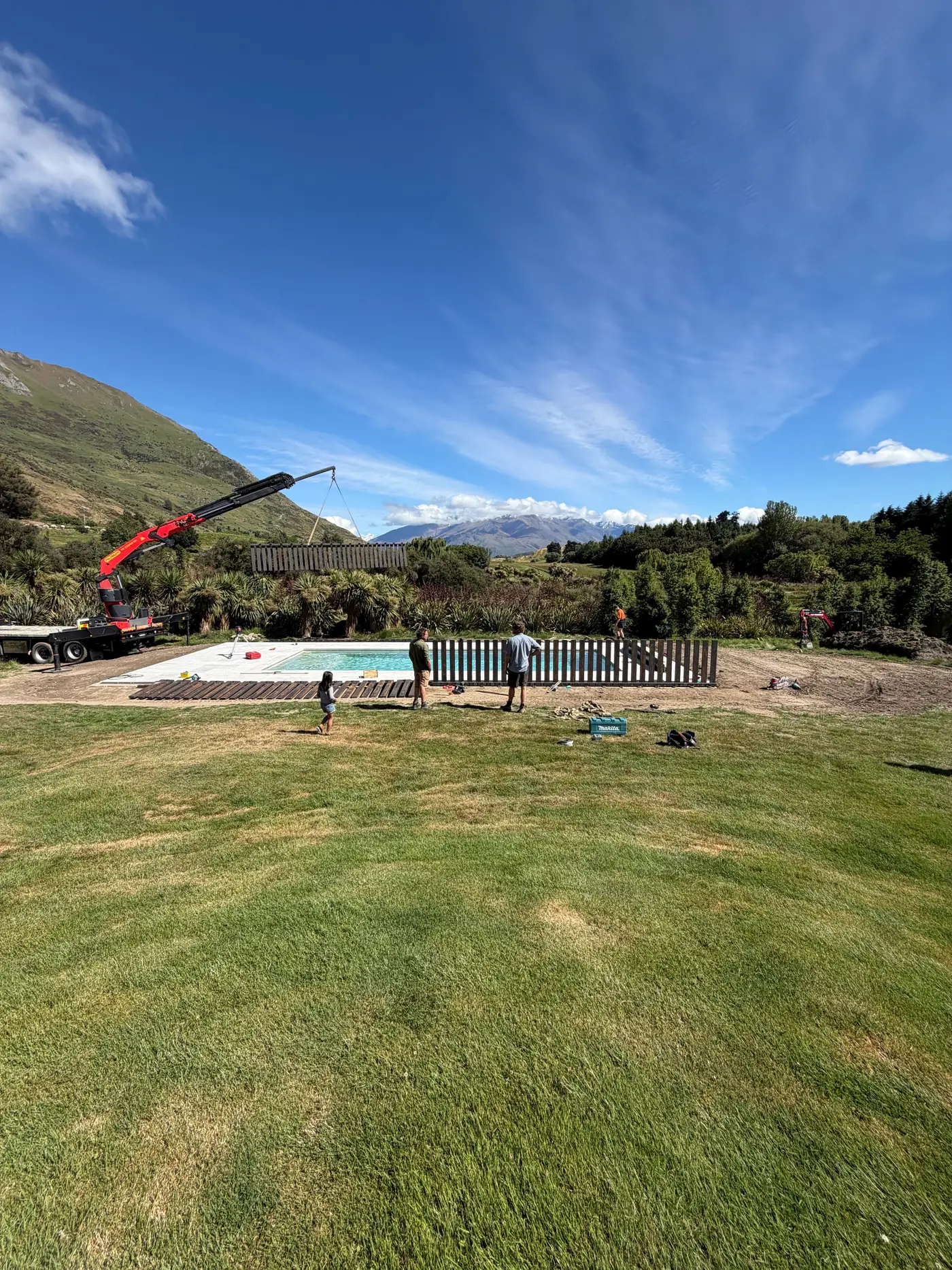 A new pool at the edge of a lawn, ready for landscaping