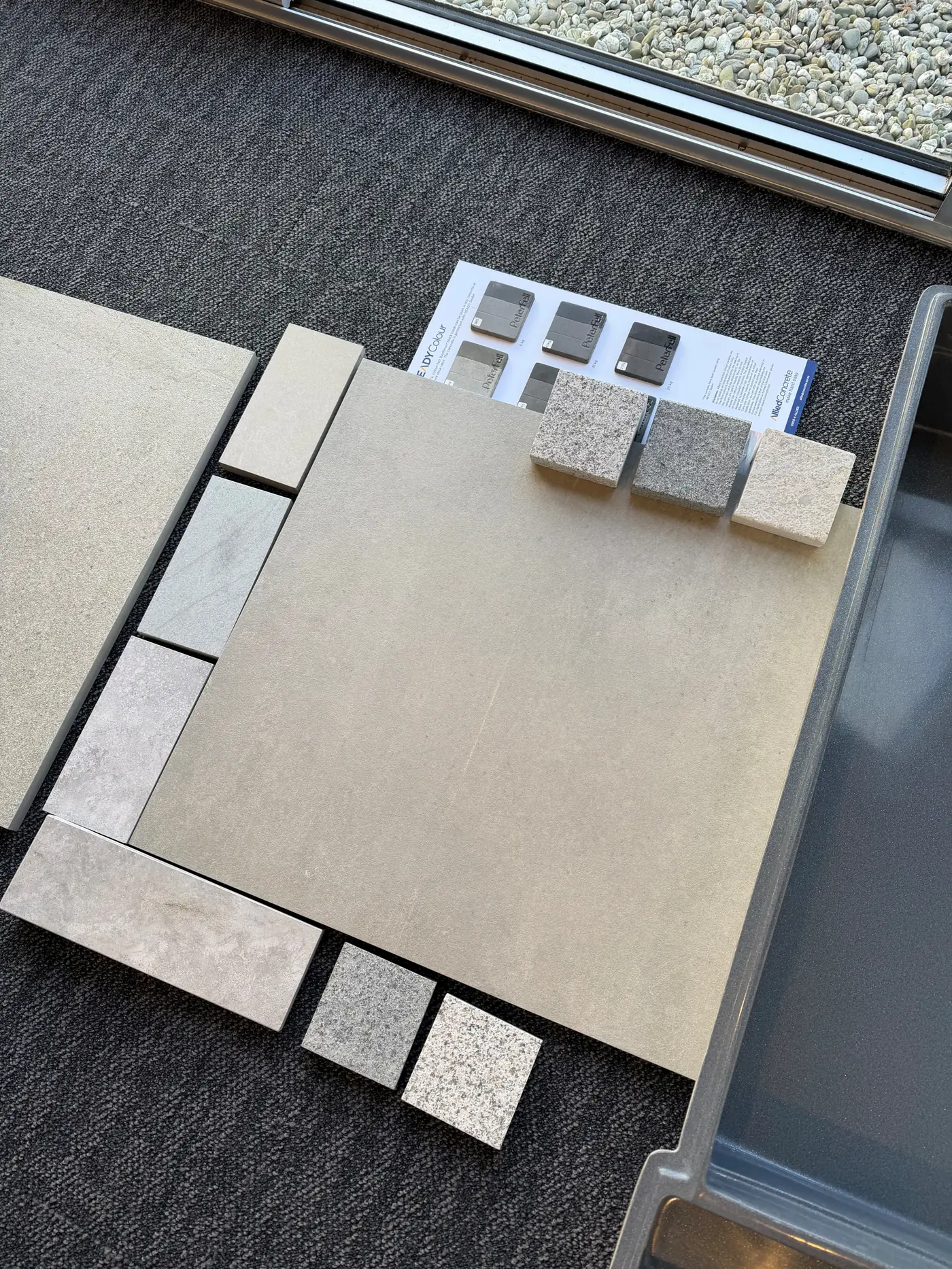 Paving and tile samples laid out beside a plan